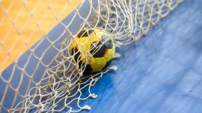 En handboll ligger på golvet i ett handbollsmål.