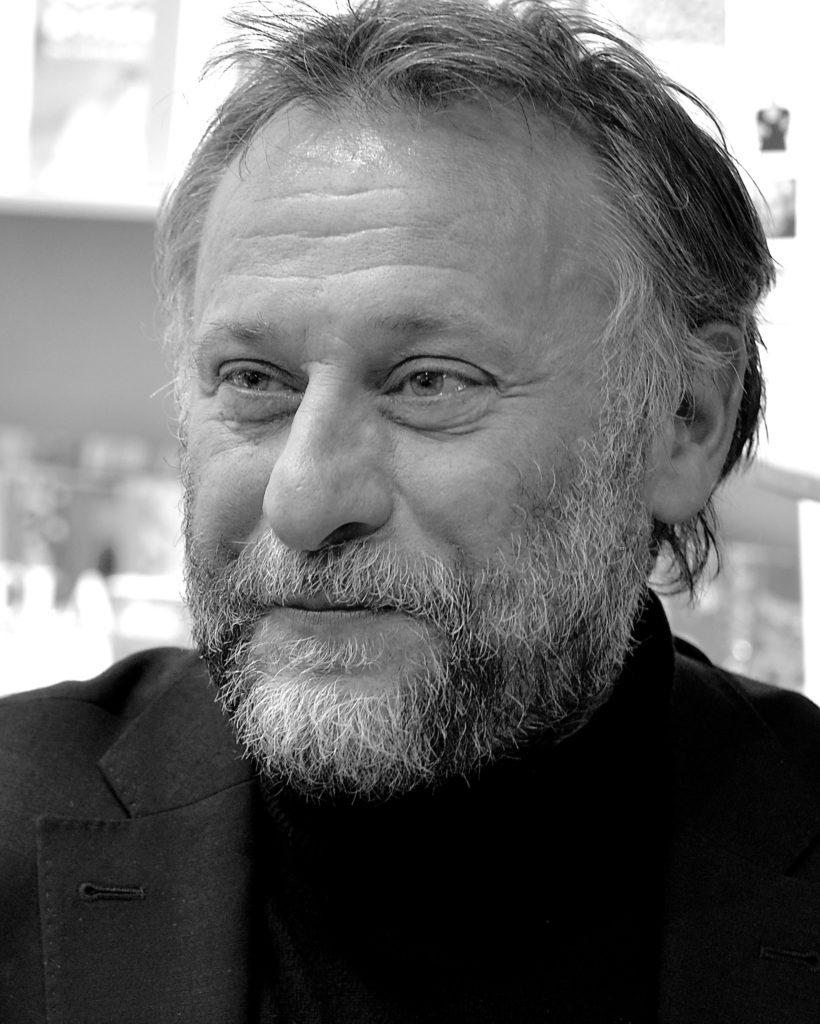 En svartvitMichael Nyqvist ler svagt.