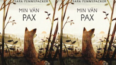 En ensam räv sitter och tittar ut över vildmarken.