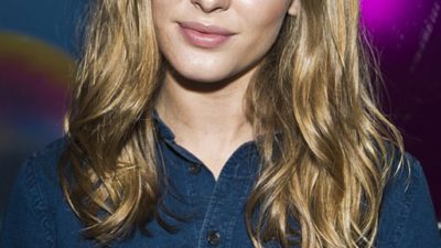 Zara Larsson tittar in i kameran. Hon har långt blont hår och en blå skjorta.