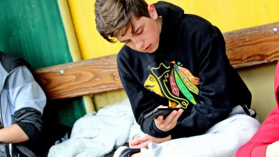 En kille som läser i sin mobil